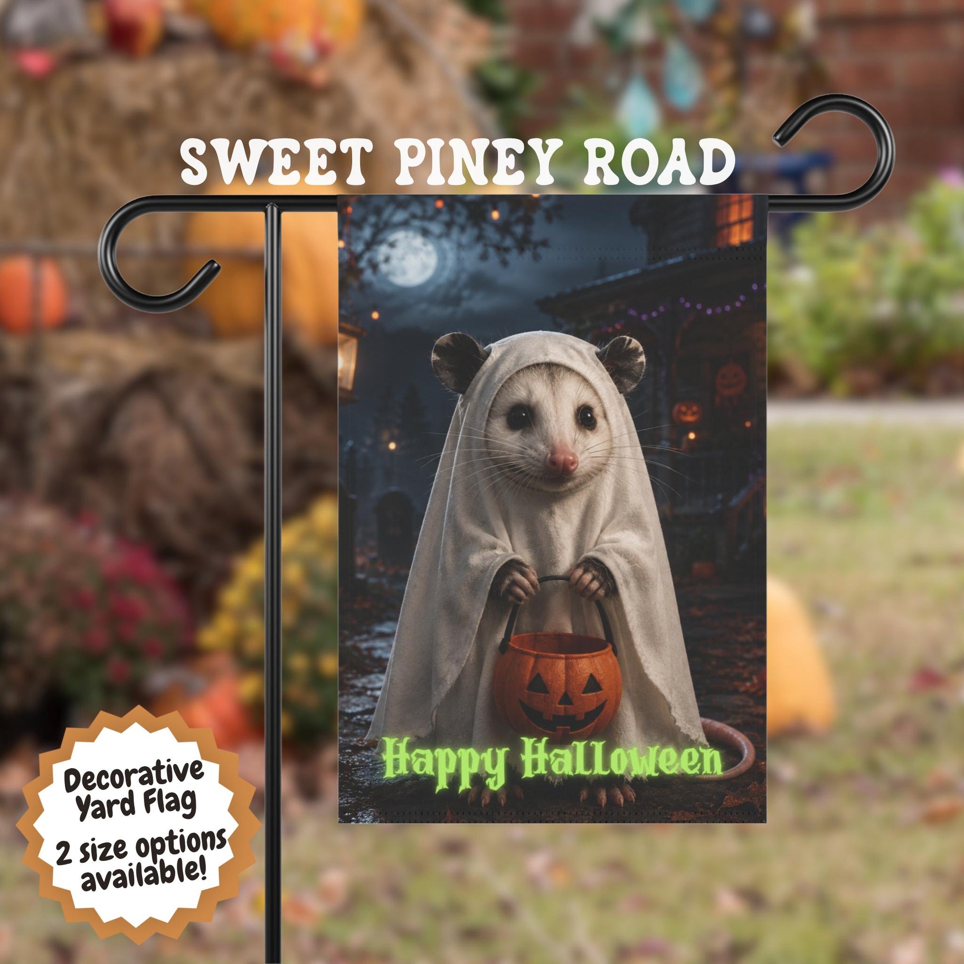 Halloween possum yard flag featuring a cute possum dressed in a white ghost costume holding a pumpkin candy bucket in a moonlit autumn yard with spooky Halloween decorations and glowing lights.
