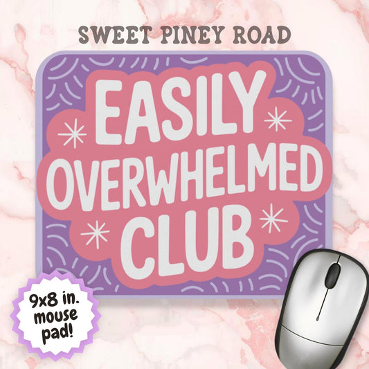 Pastel purple and pink mouse pad featuring the phrase "Easily Overwhelmed Club" in large white lettering. Colorful retro-style design with decorative starbursts and playful pattern accents, created as a humorous desk accessory for ADHD, anxiety, and mental health themed workspaces.