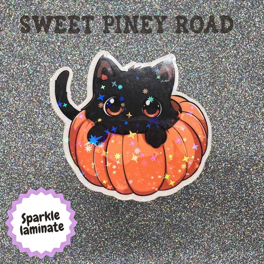 Cute kawaii black cat peeking out of an orange pumpkin sticker with large orange eyes and a whimsical autumn Halloween design, displayed on a holographic background.