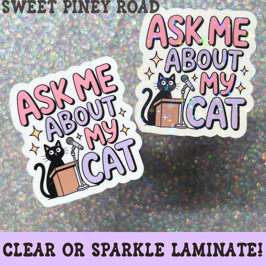 Cute cat lover sticker featuring a black cat standing at a podium with a microphone and the phrase Ask Me About My Cat in pink and purple lettering.
