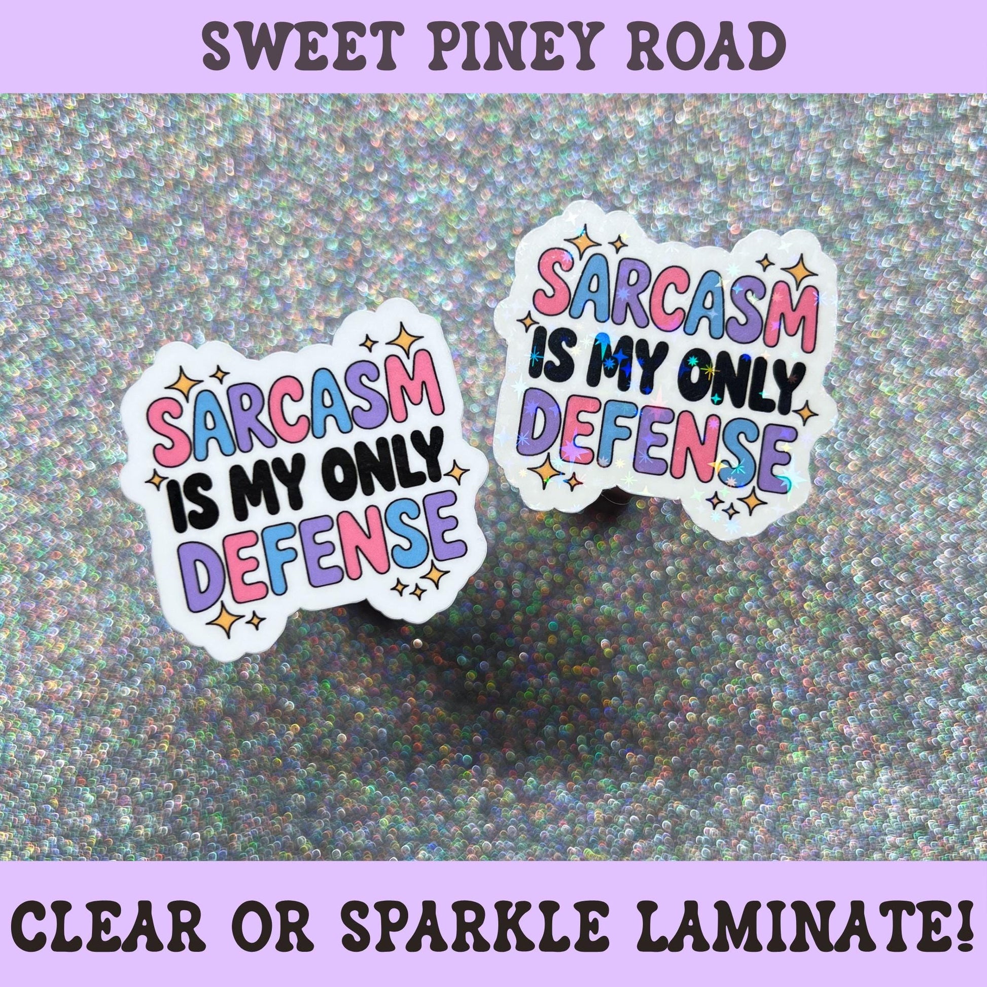 Colorful sticker featuring the phrase "Sarcasm Is My Only Defense" in pink, blue, purple, and black lettering with decorative stars.